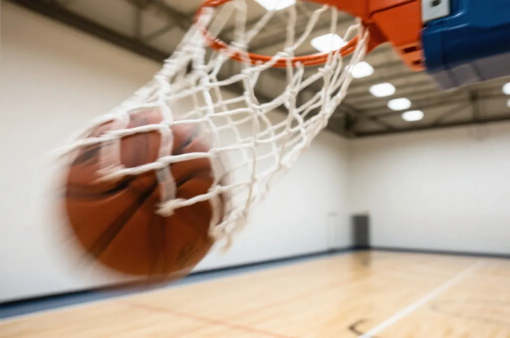 Close-up of a basketball flying through a pristine net on a clean indoor basketball court, dynamic motion blur, high-speed photography